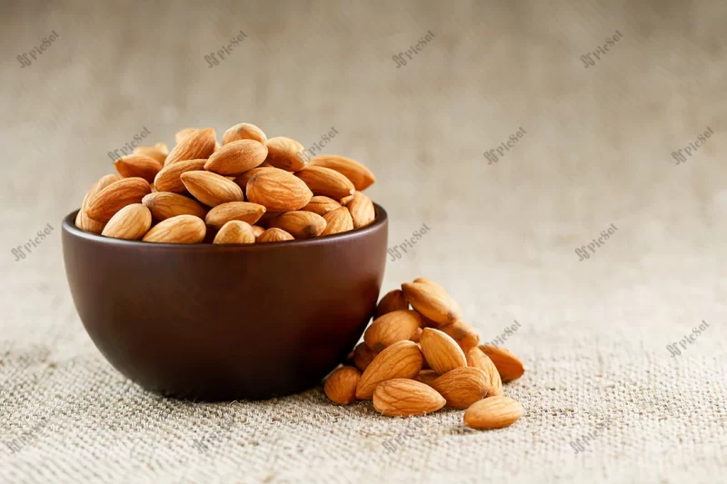 almonds wooden cup burlap cloth background / بادام در کاسه