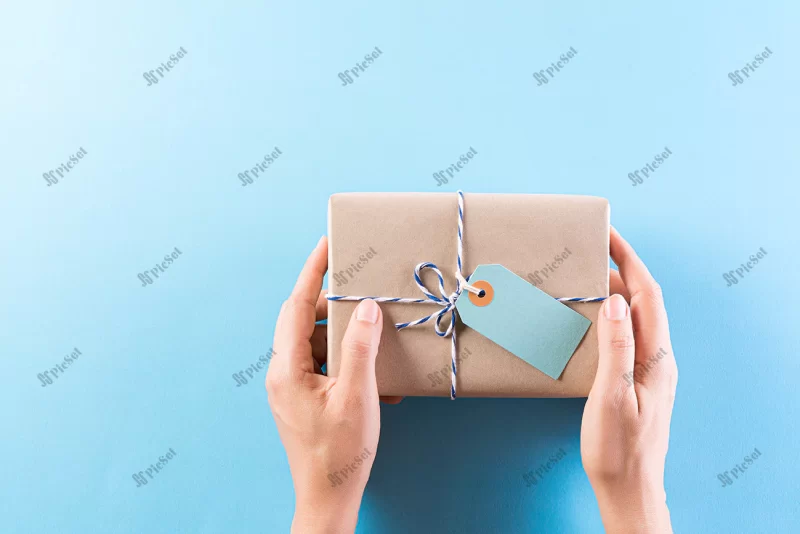 hand giving gift box with greeting card / جعبه هدیه دستی با کارت تبریک