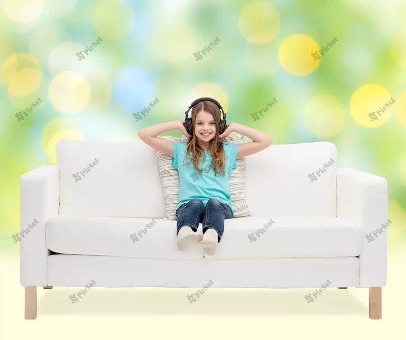 leisure technology music childhood concept smiling little girl headphones listening music sitting sofa green lights background / فناوری اوقات فراغت کودک خندان، دختر نشسته روی مبل و هدفون در گوش و گوش دادن به موسیقی