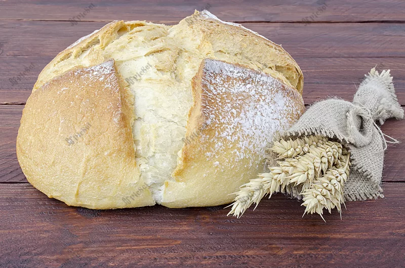 loaf bread / قرص نان و دسته گندم روی میز چوبی