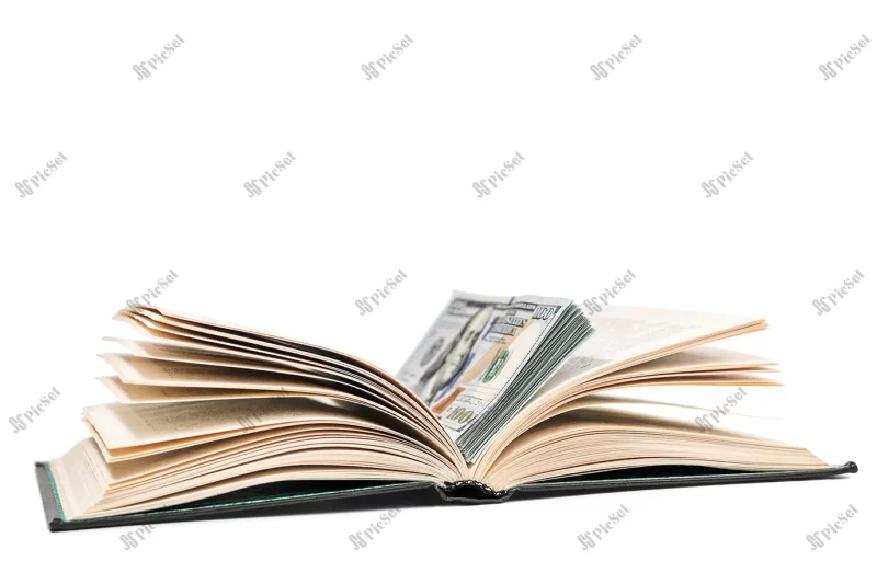 open book with stack dollars lying it isolated white background / کتاب باز با اسکناس دلار وسط صفحات کتاب مفهوم پس انداز