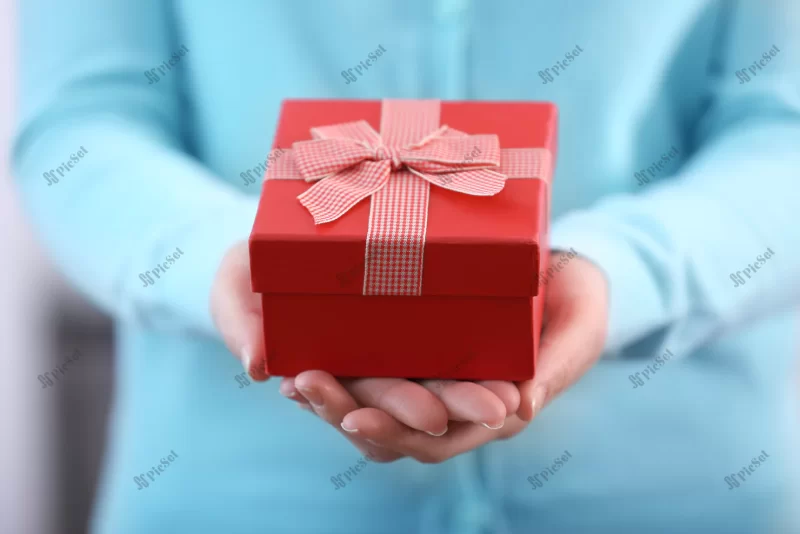 woman holding beautiful gift box closeup / زنی که جعبه هدیه قرمز زیبا را در دست دارد