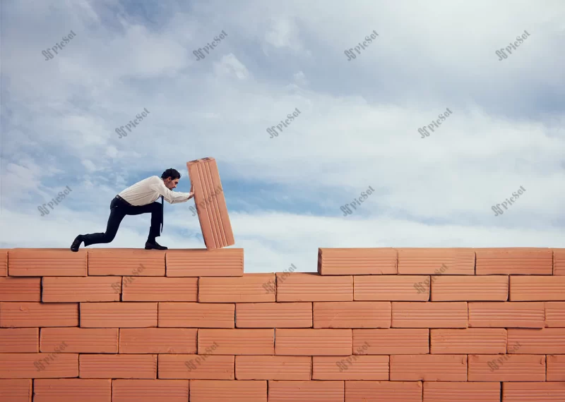 businessman puts brick build big wall concept new business partnership integration startup / تاجر با طرح ساخت دیوار آجری بزرگ مفهوم استارتاپ و مشارکت تجاری جدید