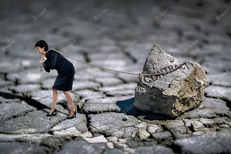 businesswoman tied her rock heavy contract dragging it ground / یک تاجر زن قوی سنگ سنگین را با طناب روی زمین می کشد