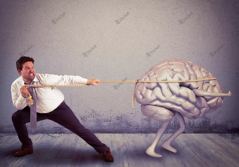 man pulls rope with brain drain / مردی فرار مغزها را با طناب می کشد