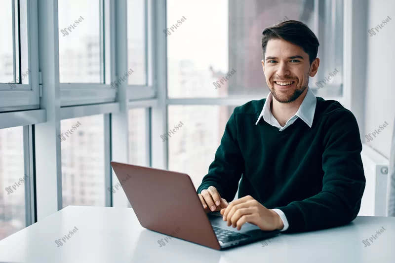 young man with laptop business suit working office home background window interviewing online / مصاحبه آنلاین مرد جوان با کت و شلوار تجاری لپ تاپ دفتر کار با پنجره